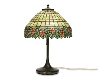 1189
Early/mid-20th century
An Arts & Crafts-Style Leaded Glass Table Lamp
Shade and base appear unmarked
The leaded glass shade with chartreuse square brick pattern and pink and green floral border on a two-light patinated metal base, electrified
Overall: 23.75" H x 16.125" Dia.; base: 23.75" H x 8" Dia.; shade: 8.875" H x 16.125" Dia.
Estimate: $1,500 - $2,000