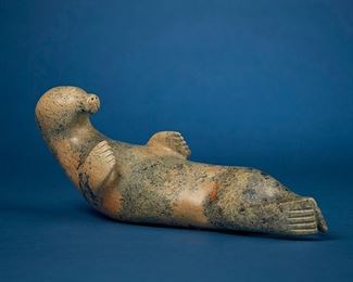 1206
Nalenik Temela
1939-2003, Inuit; Lake Harbour/Kimmirut
Carved Seal Figure, 1980
Stone
Signed syllabically to underside and dated: 1980 / ©
3.875' H x 11.5" W x 4" D
Estimate: $400 - $600