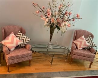 Pair of Queen Anne style wing chairs and pillows (included in purchase price if wanted), glass and metal coffee table and floral display in large vase. Faux floral arrangement: Flowers by Joan.