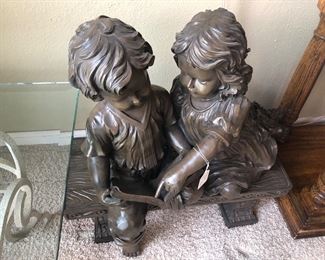 Statue, boy and girl on bench. Plaster or composite material.