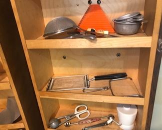More kitchen gadgets, including aluminum measuring cups, various slicers, vintage scoops, good sieve.