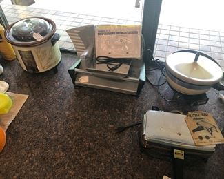 Tremendous variety of electric kitchen gadgets and small appliance, some of them vintage. All work well. Among these are the crock pot, deli slicer, and vintage Pizzelle maker.