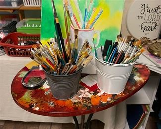 Funny paint pallet table, lots of paint brushes, original art piece