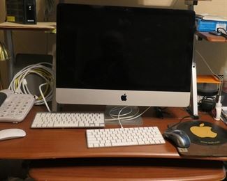 Two of two Apple desk top computers. Two of the three Apple keyboards. Small work deak