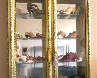 Shoe collection in double door gold gilt display case.
