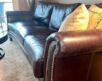 Dark brown leather sofa with nail head trim and bun feet by Hooker Furniture 