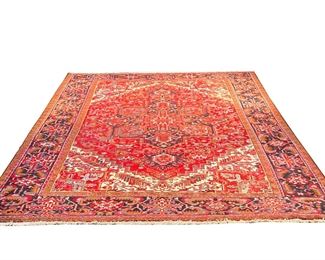 HERIZ HANDWOVEN CARPET | Mid-20th century, red ground with flower and vine border, central medallion, geometric devices - 13 ft 6 in x 10 ft 1 in. - l. 162 x w. 121 in