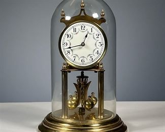 GERMAN SHELF CLOCK | In a glass dome, enameled dial with Arabic numerals. - h. 11 in