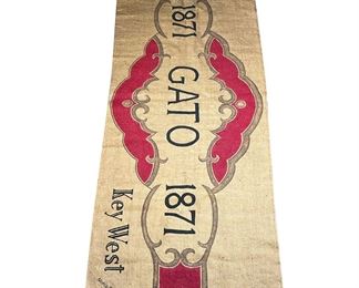 NOELLE ROSE BURLAP FLOOR MAT | Decorated with an oversize cigar wrapper design, "Gato / 1871 / Key West". - w. 76.5 x h. 28.5 in