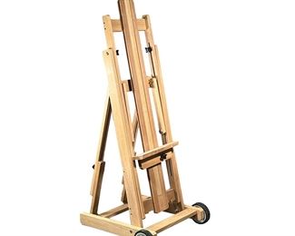 ARTIST’S EASEL | Solid wood with two wheels; folds flat. - l. 20 x w. 7 x h. 54 in (folded)