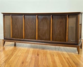 MAGNAVOX STEREO CONSOLE | Long mid-century modern stereo console with built-in record player by Magnavox; walnut panels, sliding door top; c. 1960s. - l. 59 x w. 18 x h. 26 in