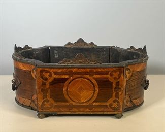 ANTIQUE JARDINIERE | Contrasting inlay / veneer with metal hardware, on four feet. - l. 14-1/2 x w. 8-1/2 x h. 6-3/4 in