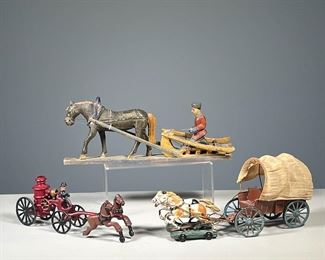 (3PC) HORSE & CARRIAGE TOYS | Cast iron horses carrying a firefighter and his trusty fire pumper; a wooden horse pulling a farmer and plow “Made in Soviet Union”; two horses on wheels pulling a covered wagon. - l. 12.75 x h. 5.5 in (wooden horse figure)