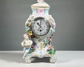 CHARLES DUPONT PORCELAIN CLOCK | Showing a winged putti / cherub among blossoming, colorful flowers. -  l. 8 x w. 6 x h. 14 in