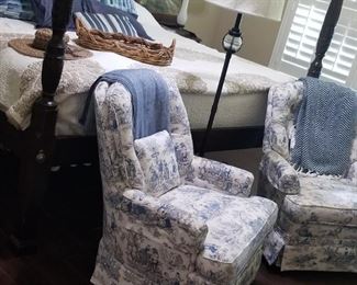View into the main bedroom, four poster bed and two comfortable chairs