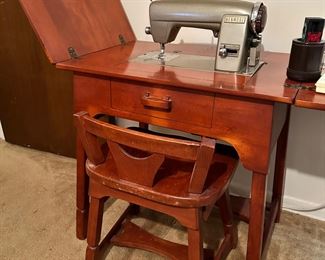 Vintage Kenmore sewing machine in cabinet with matching stool