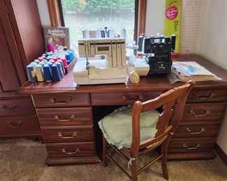 Executive desk used as sewing table. 2 huskylock machines, manuals and accessories, many spools of overlock thread, 