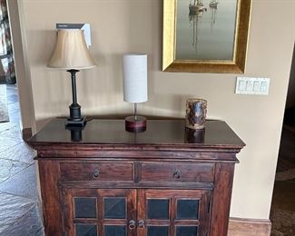 Handsome console cabinet, exciting lighting, and an oil on canvas boat painting by Jeff Sabol.