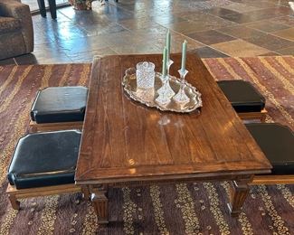 Low coffee table with ottoman seating, Waterford bisquit jar, and a room size rug.  Note the two handsome console tables in the background.