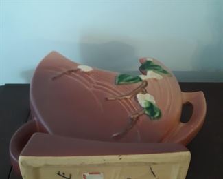 Roseville pottery is located on the buffet near the dining table.