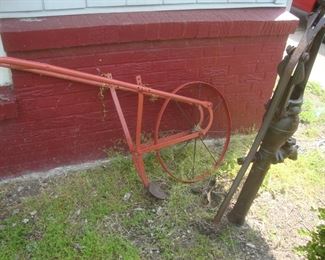 Old metal hand plow, cast iron water pump