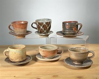 (6PC) MEG SMEAL POTTERY CUPS & SAUCERS | Mostly with brown glaze by Meg Smeal and other Potters. -  dia. 6.5 in (largest saucer)