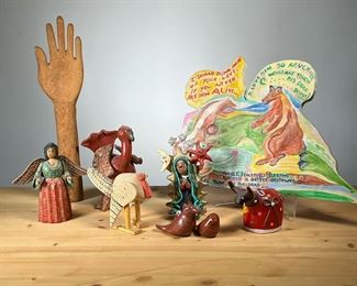 (9PC) JOSEFINA AGUILAR & OTHER | Including a sculpture by Josefina Aguilar (Mexican, 20th/21st Century): a handmade pottery figure of a religious female figure with sun, moon, and stars, signed on verso; plus other handmade pottery figures, including a turkey, bull, and a pair of birds; plus a wooden hand model, a carved and painted wood turkey, an angel, and a painted wood sign, dated 1982 and signed "Hudeli(?) Anne... ?" - h. 10.5 x dia. 3.5 in (Woman Figure)