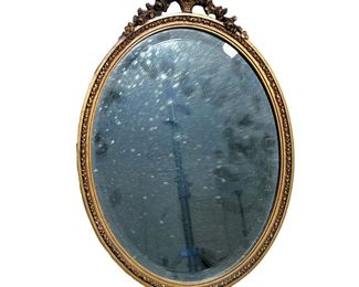 GILT MIRROR | Round gilt mirror with aged glass; basket motif on top. -  l. 16.5 x w. 12 in