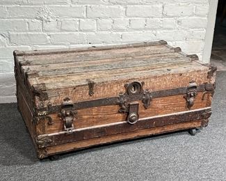 ANTIQUE WOOD TRUNK | An antique wood trunk with iron hardware and four casters. - l. 34 x w. 20 x h. 14.5 in
