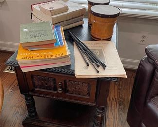 Side table with black slate top; music books, and bongo drums