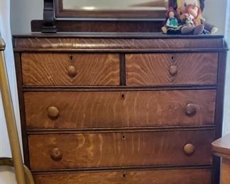 Tall chest of drawers with attached mirror.