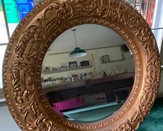 Large, substantial round mirror with beveled mirrored glass.  This piece definitely makes a statement when hung on the wall.