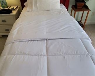 Cherry twin bed with linens. 