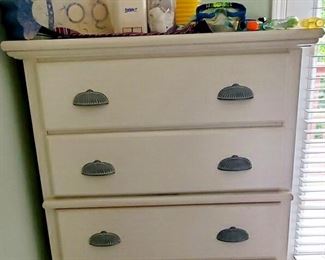 Tall white chest with scalloped handles. 