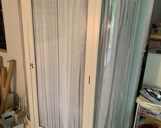 Very large curved china cabinet fitted with curtains for storage