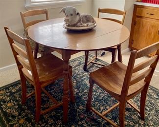 Nice drop leaf table with four chairs and check out the stoneware cow platter!!! 