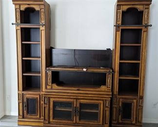 Entertainment center (shown disassembled with center piece laying upside down on bottom cabinet)