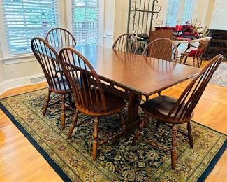 Solid cherry trestle table and 6 chairs. Includes two expansion leaves and table top pads