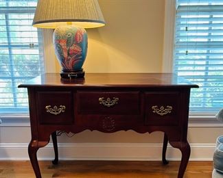 Bassett  Petite credenza in walnut with traditional Queen Anne embellishments.
Dovetailed drawer construction
Brass hardware
Cabriole legs with pad feet. 
Three drawers