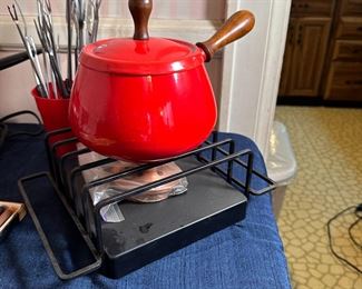 Red fondue pot with black metal warming stand