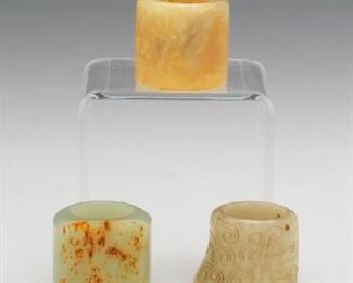 A Group of Three Archer Jade Rings 