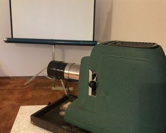 Retro slide projector and screen. Projector has carrying case. Includes cases for slides, too. Very cool retro vibe, and yes, it works!