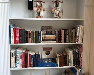 Living Room:  This bookcase has books written in English.  Also displayed are ceramic Chinese figures and two small clocks.