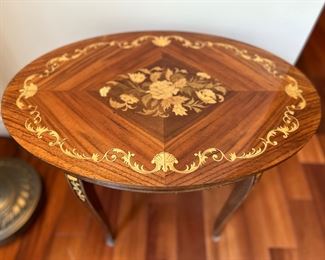 Living Room:  A small handcrafted, oval Italian inlaid marquetry/rosewood/satinwood  table has a music box inside. The table is signed "Reuge."