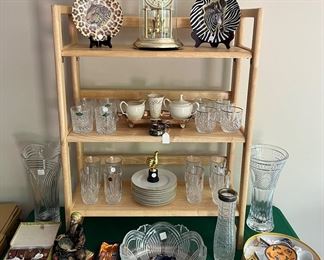 Sun Room:  Decorative plates flank an Elgin anniversary clock.  Also shown are sets of crystal glasses; LENOX; MIKASA vases; a set of cloisonné napkin rings; a cup and saucer tea set; and other items.