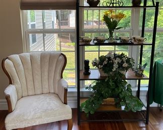 Sun Room:  An ivory color channel-back sofa is to the left of a four shelf display rack (36" wide x 15" deep x 72" tall) which has floral arrangements and table top decor.