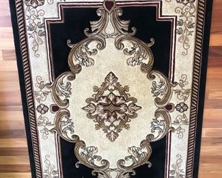 Sun Room:  A machine made rug in beautiful colors of black, gold, and maroon measures 5'  2"  x  7'  5."