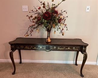 Upstairs Hall:  A Chinoiserie two-drawer sofa table has a raised gold design, as better seen in the next photo. It measures 58" wide x 18" deep x 27" tall.  The floral arrangement is also for sale.
