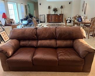 Lower Level:  The 89" leather sofa has attached back cushions and detached seat cushions.  It matches the nearby over-size chair.  (A photo of the back side of the couch is in the next photo.)