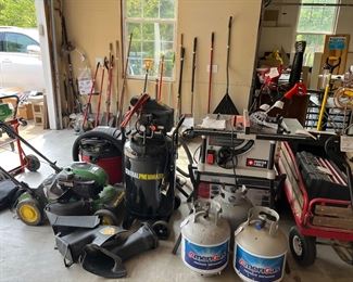 Garage:  This garage is packed with quality tools. 
For starters:  a John Deere self-propelled/electric start  190 cc/6.75/ (JS30] lawn mower; CENTRAL Pneumatic 21 gallon/25 HP/125 PSI compressor; a PORTER CABLE 10" portable table saw; two propane tanks; and a red wagon (on the right).